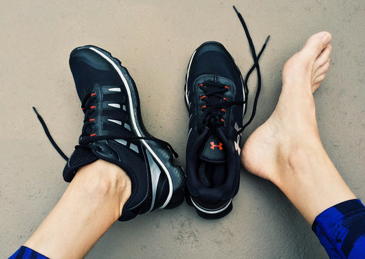 Photo of stinky feet being placed outside of stinky shoes in a blog for Skunk Skin odorless socks.